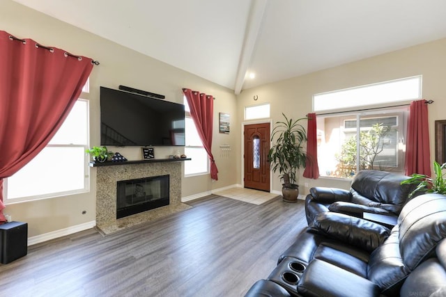 living room featuring vaulted ceiling with beams, a high end fireplace, and wood-type flooring