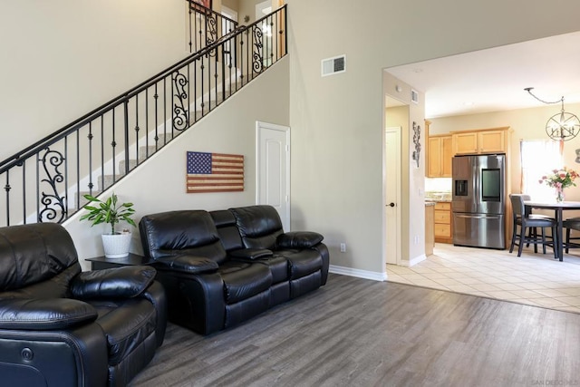 living room with a high ceiling and light hardwood / wood-style flooring