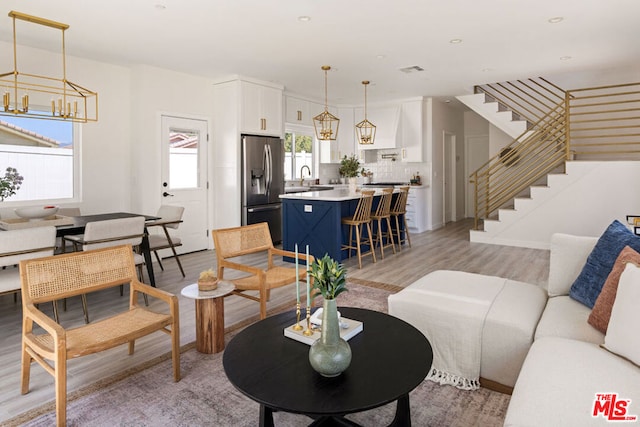 living room featuring plenty of natural light, sink, and light hardwood / wood-style flooring