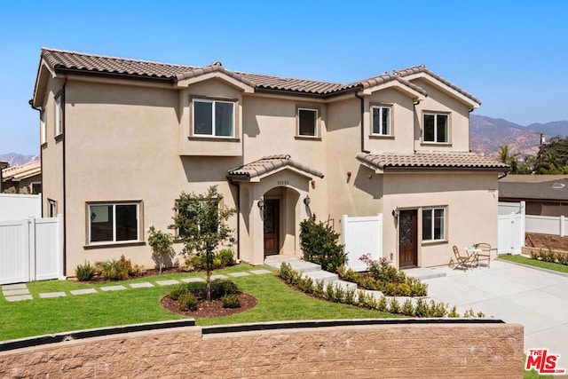 mediterranean / spanish-style home featuring a mountain view, a patio area, and a front yard