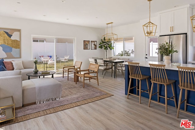 living room with light wood-type flooring and an inviting chandelier