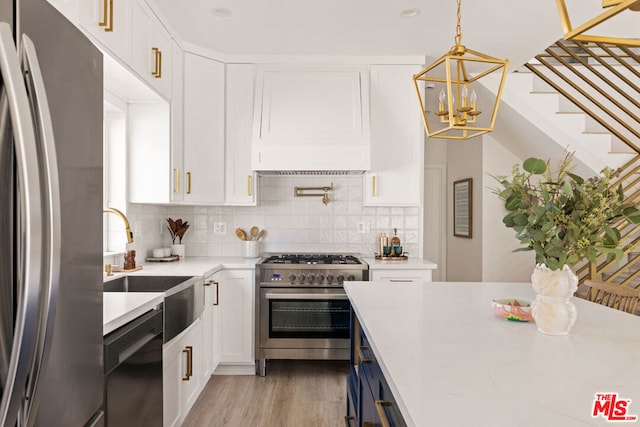 kitchen with white cabinets, light hardwood / wood-style floors, stainless steel appliances, and tasteful backsplash