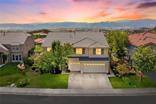 view of front of property featuring a mountain view, a yard, and a garage