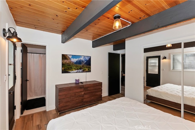 bedroom with beamed ceiling, hardwood / wood-style flooring, a closet, and wooden ceiling