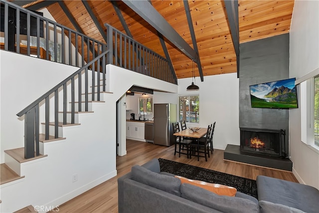 living room with beam ceiling, high vaulted ceiling, and a wealth of natural light