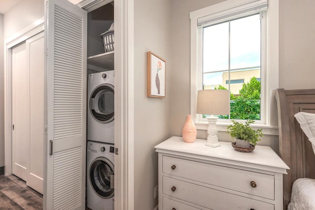 washroom featuring stacked washer / drying machine and dark hardwood / wood-style floors