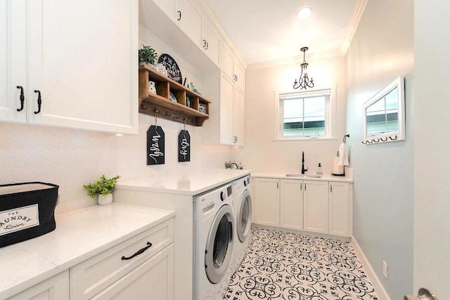 washroom with cabinets, sink, a notable chandelier, separate washer and dryer, and ornamental molding