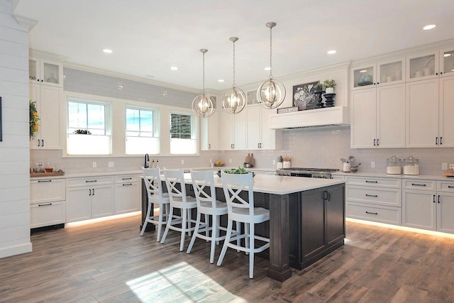 kitchen with ornamental molding, a kitchen island, and dark hardwood / wood-style flooring