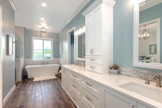 bathroom with crown molding, vanity, hardwood / wood-style floors, and plus walk in shower