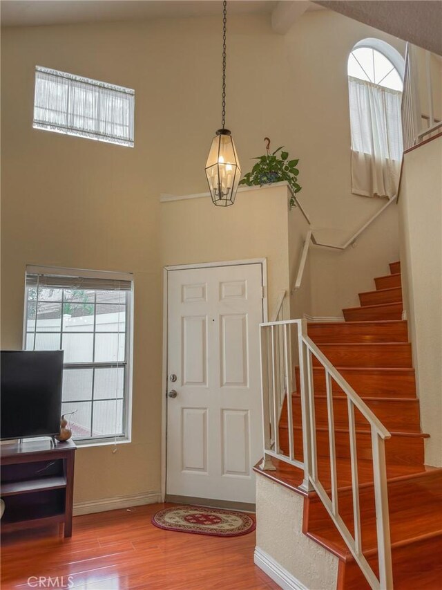 13168 Pinnacle Ct, Chino Hills, CA 91709 - foyer with wood finished floors, high vaulted ceiling, stairs, a chandelier, and beam ceiling