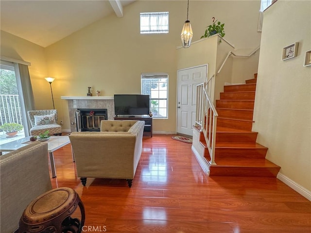 living room featuring beam ceiling, a fireplace, plenty of natural light, and hardwood / wood-style floors