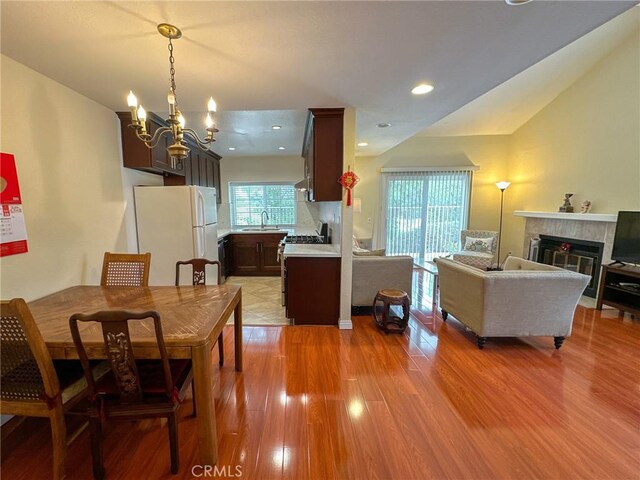 13168 Pinnacle Ct, Chino Hills, CA 91709 - dining room featuring a chandelier, light wood-type flooring, a fireplace, recessed lighting, and lofted ceiling