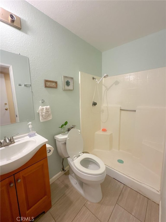 bathroom featuring vanity, toilet, and a shower