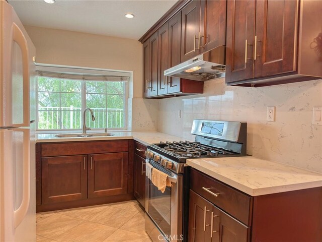 13168 Pinnacle Ct, Chino Hills, CA 91709 - kitchen with stainless steel range with gas cooktop, freestanding refrigerator, under cabinet range hood, backsplash, and recessed lighting