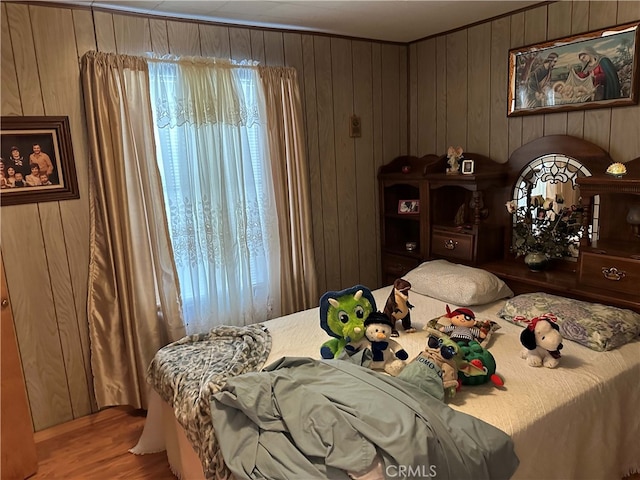 bedroom with wood walls and hardwood / wood-style floors