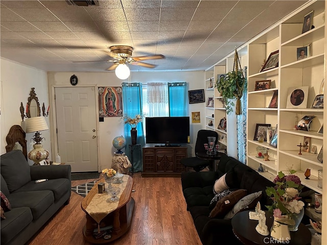 living room with ceiling fan, built in shelves, and hardwood / wood-style flooring