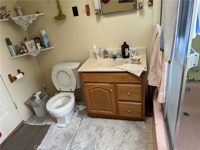 bathroom with toilet, vanity, tile patterned flooring, and walk in shower