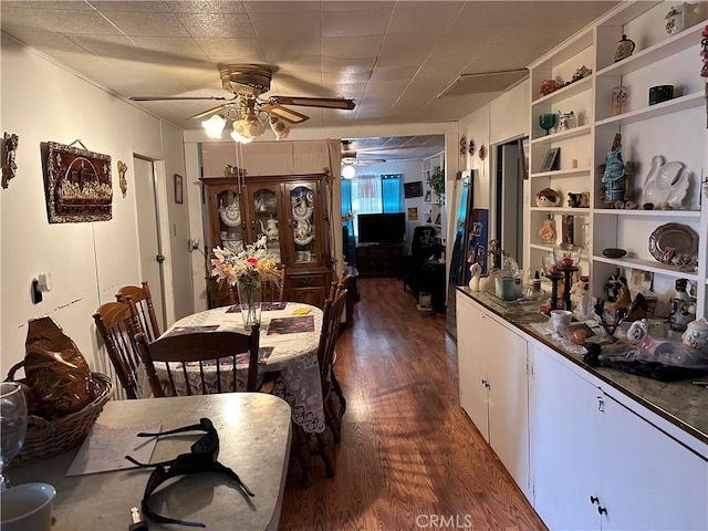 dining room with dark hardwood / wood-style flooring and built in shelves