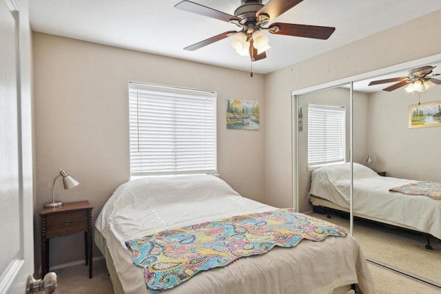 carpeted bedroom featuring multiple windows, ceiling fan, and a closet