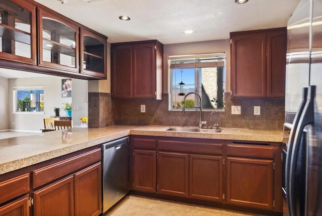 kitchen featuring kitchen peninsula, decorative backsplash, sink, and stainless steel appliances