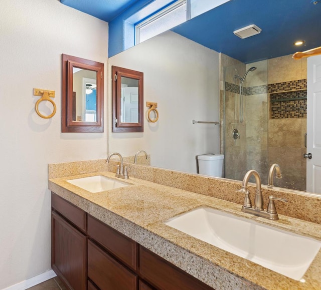 bathroom featuring tiled shower, vanity, and toilet