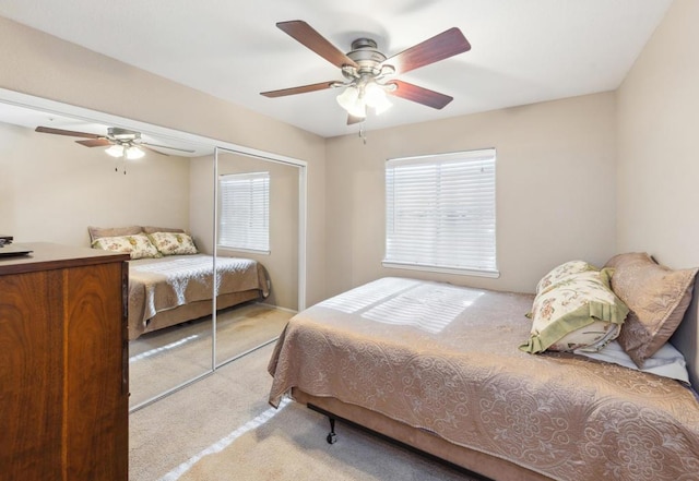 bedroom featuring ceiling fan, a closet, and light carpet