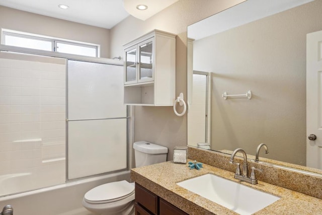 full bathroom featuring shower / bath combination with glass door, vanity, and toilet