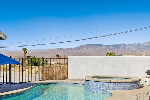 view of pool featuring a mountain view and an in ground hot tub