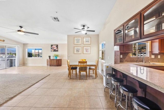 tiled dining area with ceiling fan and sink