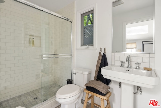 bathroom with decorative backsplash, toilet, and an enclosed shower