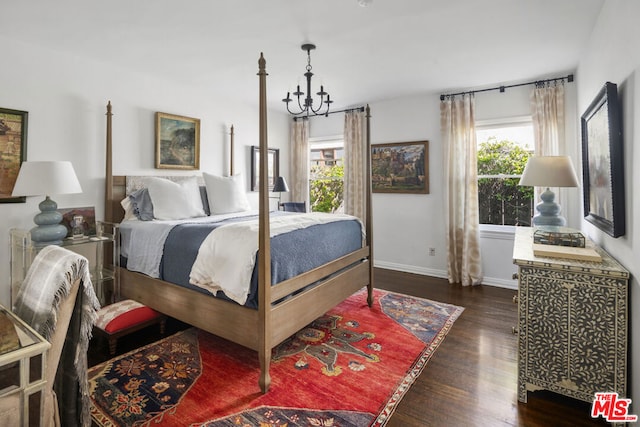 bedroom featuring dark wood-type flooring and a chandelier