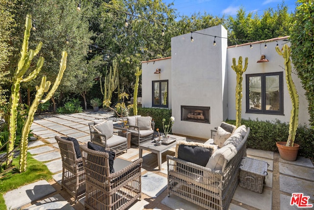 view of patio / terrace with an outdoor living space with a fireplace