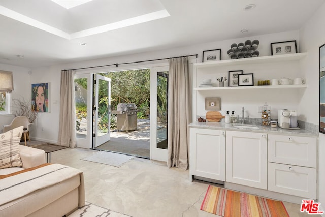 doorway featuring a tray ceiling and sink