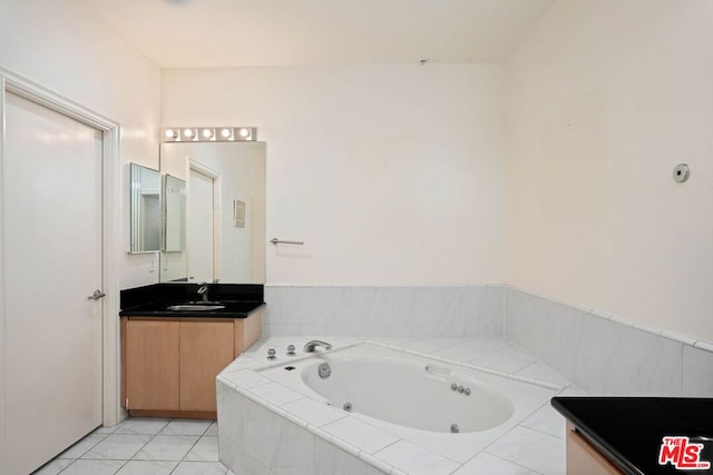 bathroom with tile patterned flooring, vanity, and a relaxing tiled tub