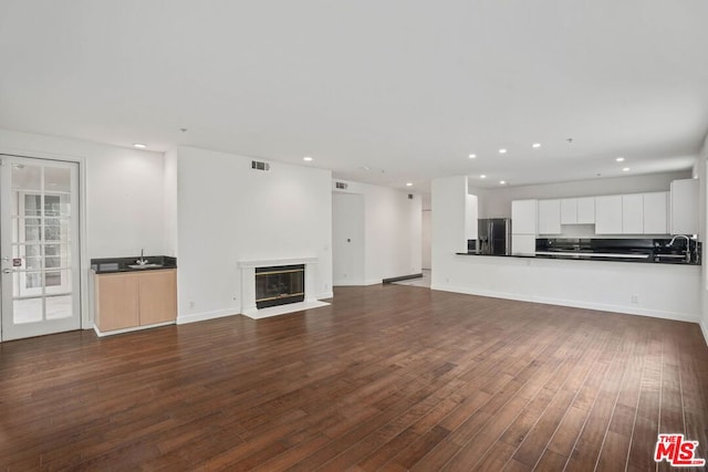 unfurnished living room with sink and dark hardwood / wood-style floors