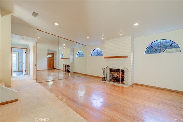 living room with light hardwood / wood-style flooring and a brick fireplace