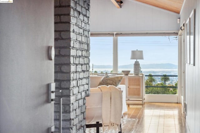 sunroom featuring a water and mountain view, wooden ceiling, and lofted ceiling