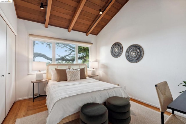 bedroom with vaulted ceiling with beams, wooden ceiling, and light hardwood / wood-style floors