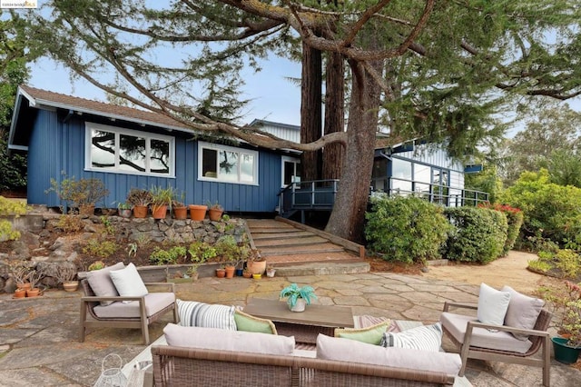 rear view of property with an outdoor living space and a patio area