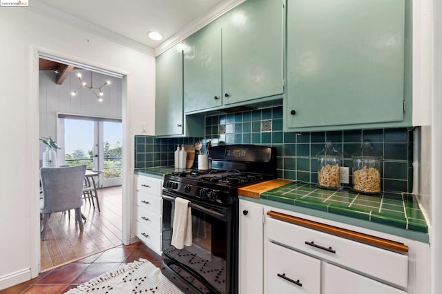 kitchen featuring tasteful backsplash, crown molding, black gas stove, dark hardwood / wood-style floors, and tile counters