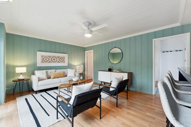 living room with light hardwood / wood-style flooring, ceiling fan, and ornamental molding