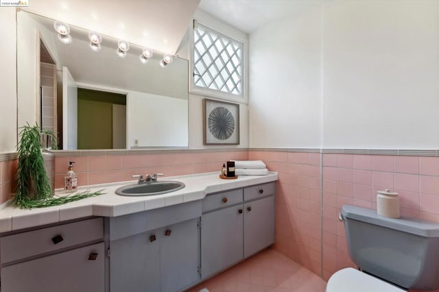 bathroom with vanity, tile walls, and toilet