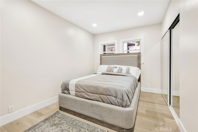 bedroom with light wood-type flooring and a closet