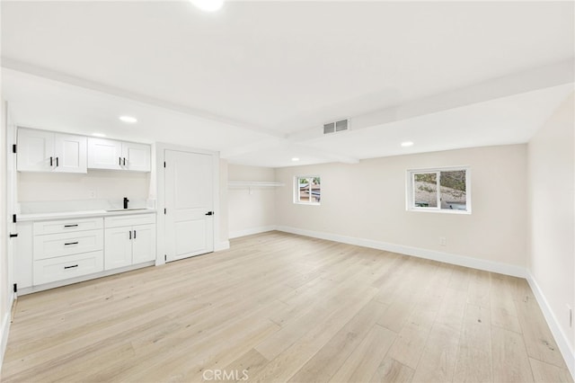 unfurnished living room with sink and light hardwood / wood-style flooring