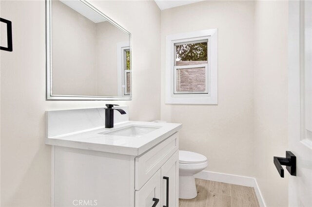 bathroom with vanity, hardwood / wood-style floors, and toilet