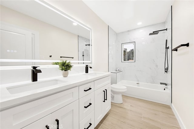 full bathroom featuring tiled shower / bath, vanity, toilet, and hardwood / wood-style flooring