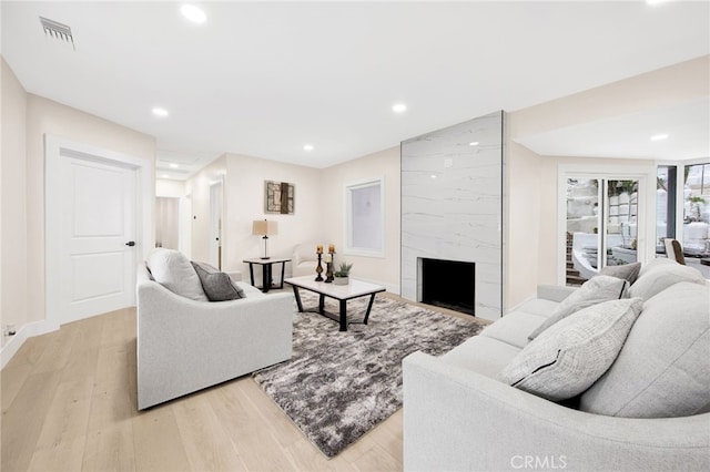 living room with light wood-type flooring and a fireplace