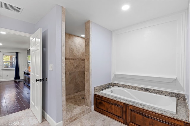 bathroom featuring hardwood / wood-style floors and independent shower and bath