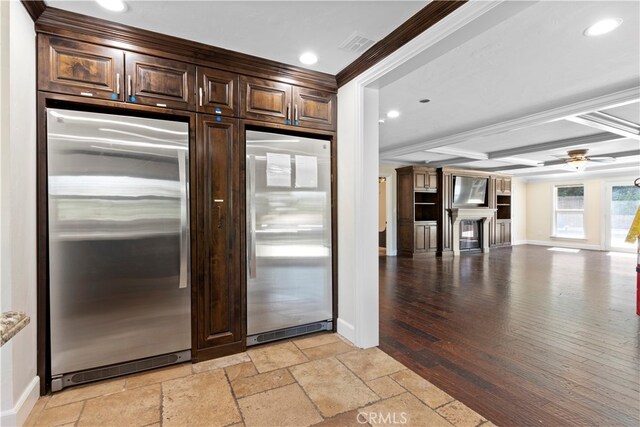 kitchen featuring stainless steel built in fridge, light wood-type flooring, beam ceiling, and ornamental molding