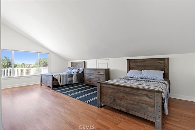 bedroom with hardwood / wood-style floors and vaulted ceiling